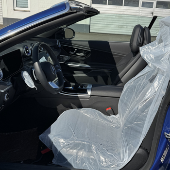 The picture shows the interior of a blue convertible with the top down. The driver’s seat is covered with the Smartgrip3in1 Eco.