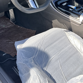 The picture shows the interior of a blue convertible with the top down. The driver’s seat is covered with the Smartgrip3in1 Eco.